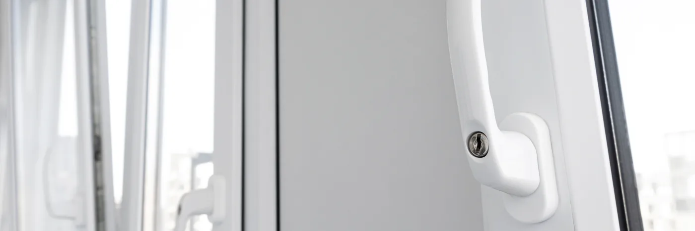 An opened white PVC window, the handle turned upright, letting outside air into the room.